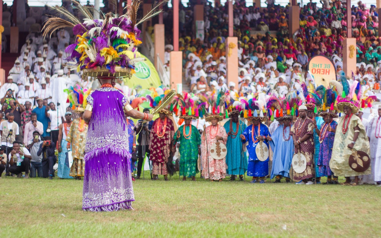 Vibrant scene from the Onitsha Ofala Festival 2024 showcasing colourful Igbo fashion and cultural performances, highlighting themes of courage and self-reliance.