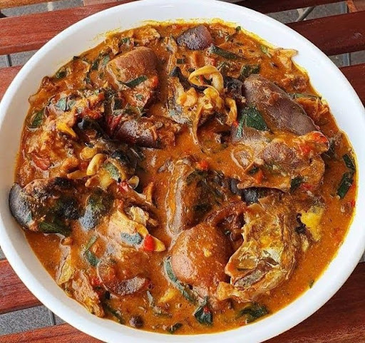 A plate of Ogbono Soup made from wild mango seeds with a rich, slimy texture and filled with vegetables and lean protein