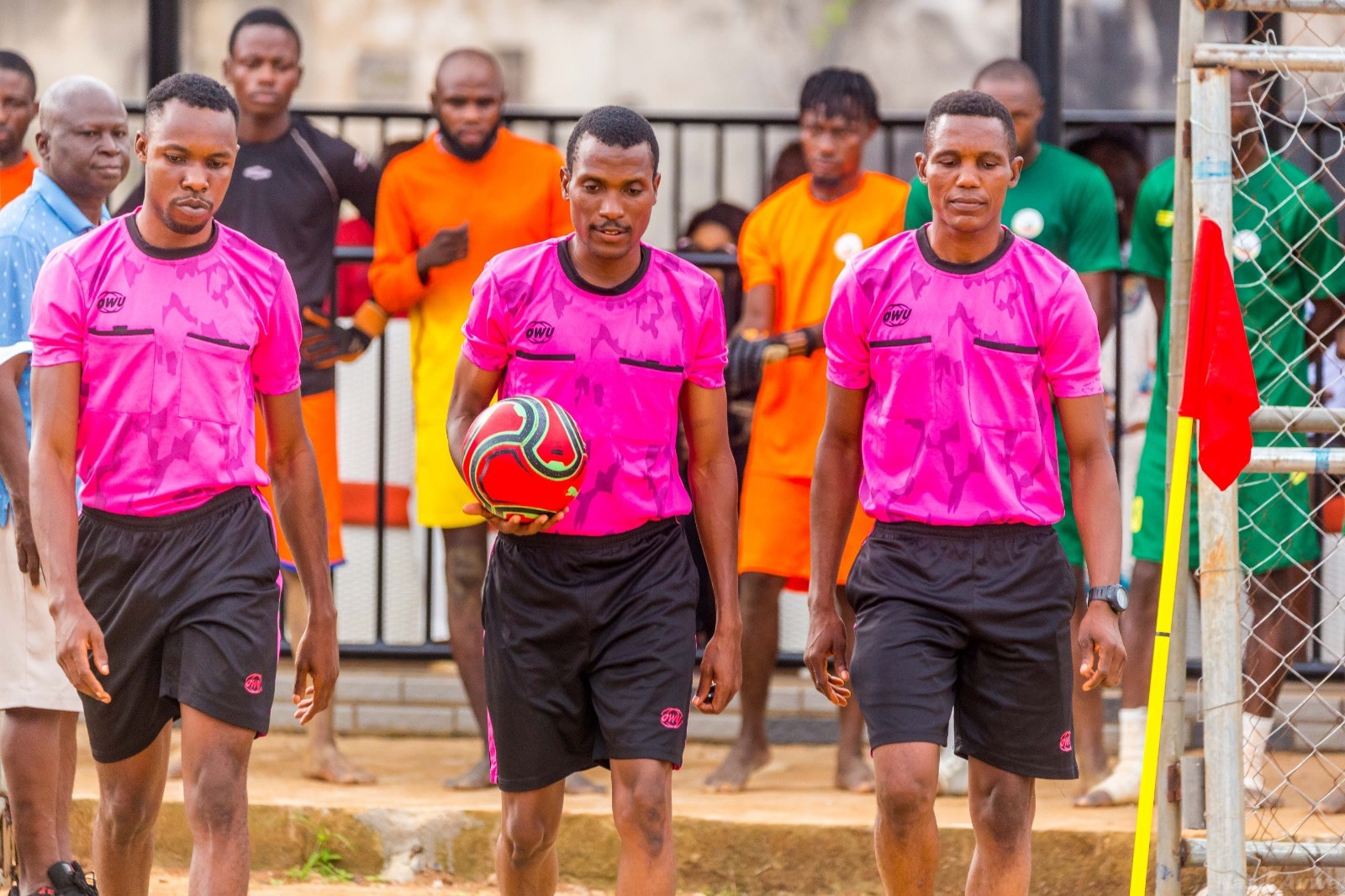  Referees walk onto the sandy pitch before officiating a beach soccer match
