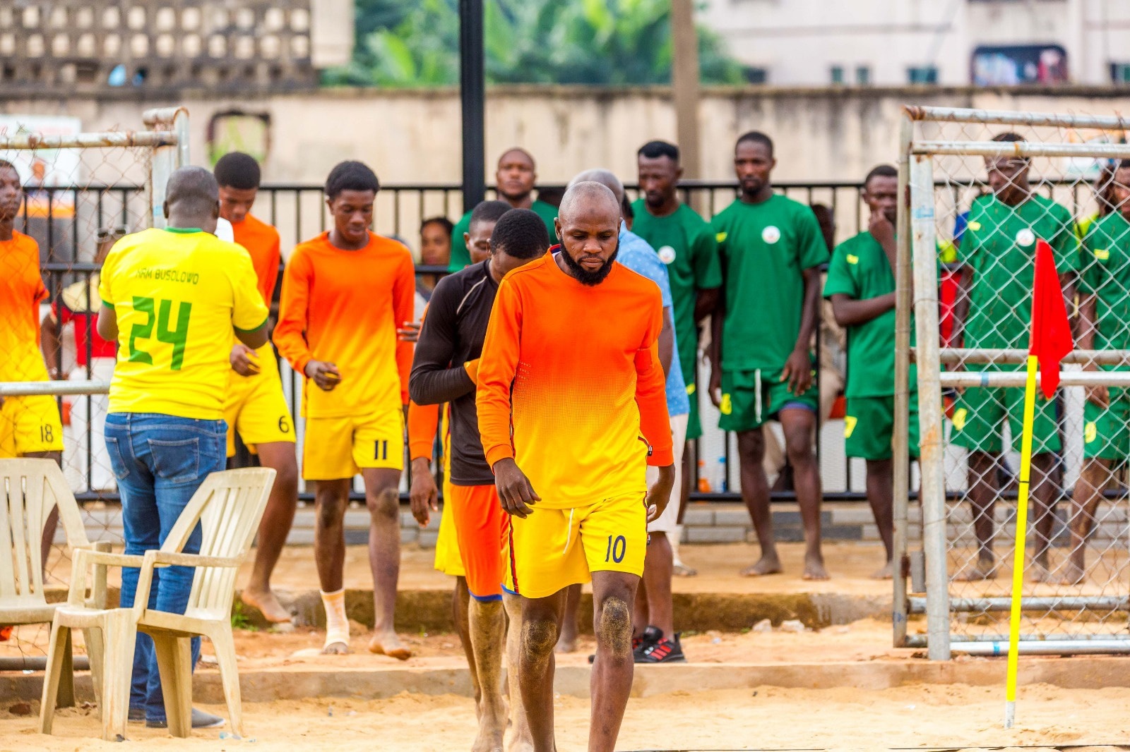 Players walks off the pitch surrounded by teammates and opponents after a competitive Nigerian Beach Soccer League 2025match