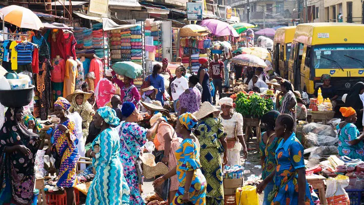A picture of traders interacting with a customer as they navigate Nigerian festive markets efficiently.