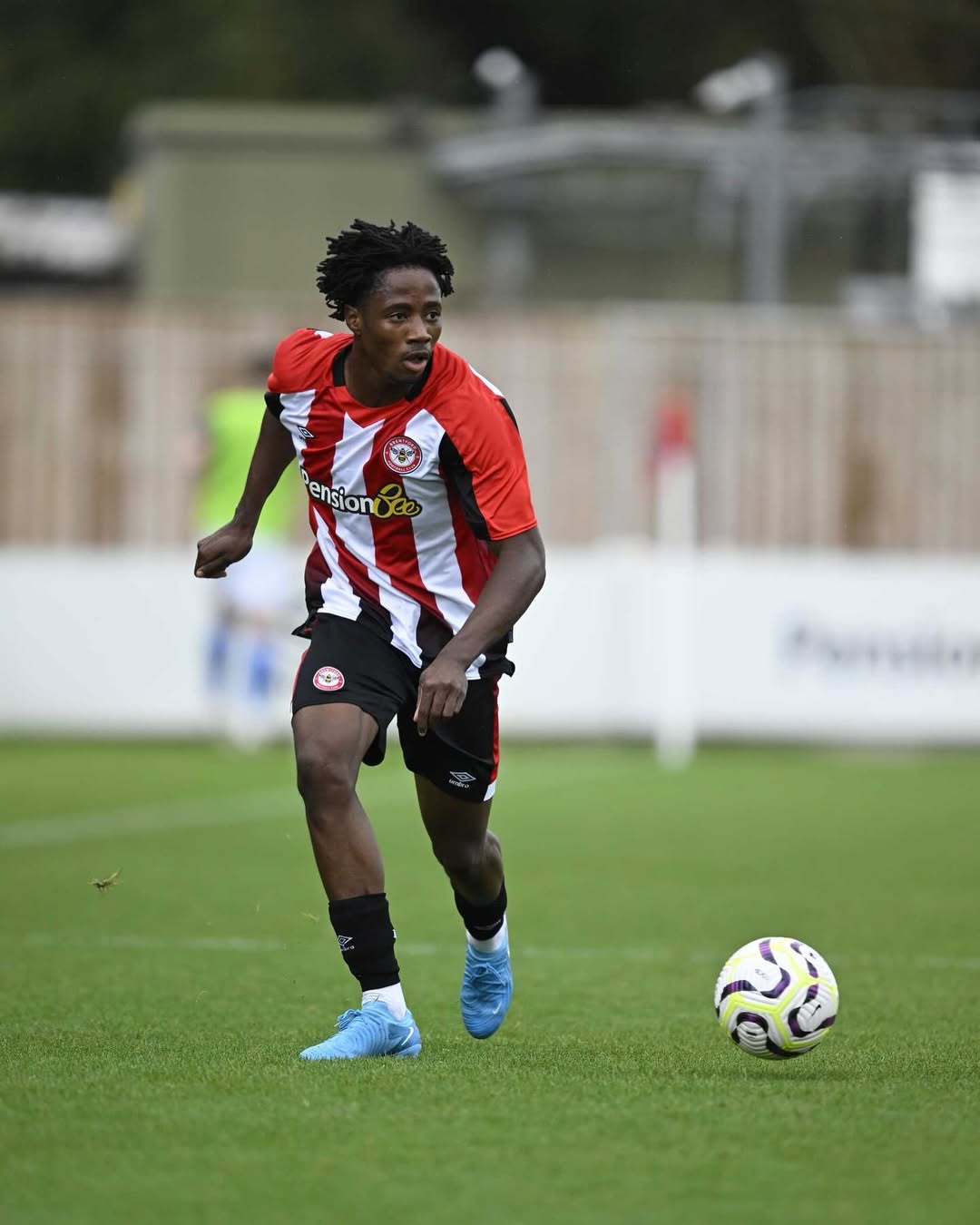 Benjamin Fredrick dribbles forward with the ball at his feet in Brentford B's home kit during a competitive fixture