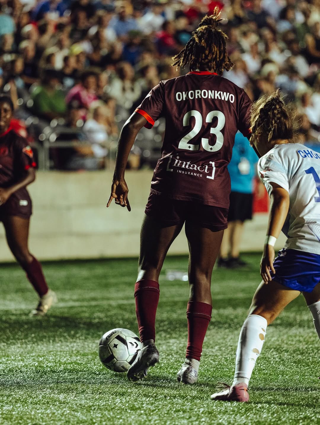 Esther Okonkwo controls the ball during a professional soccer match 

