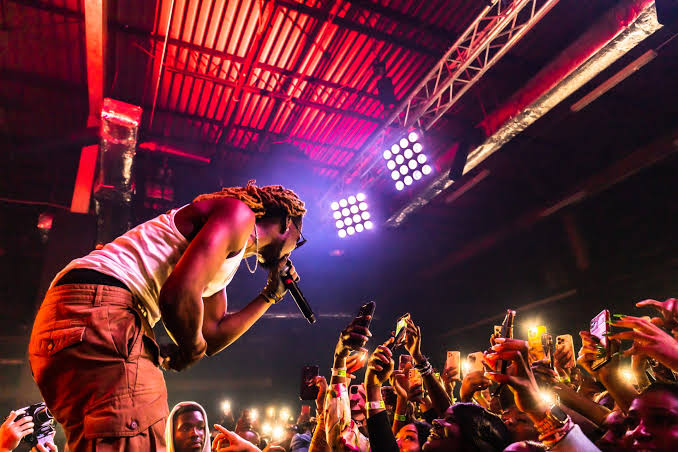 Asaka performing on stage during a Detty December concert