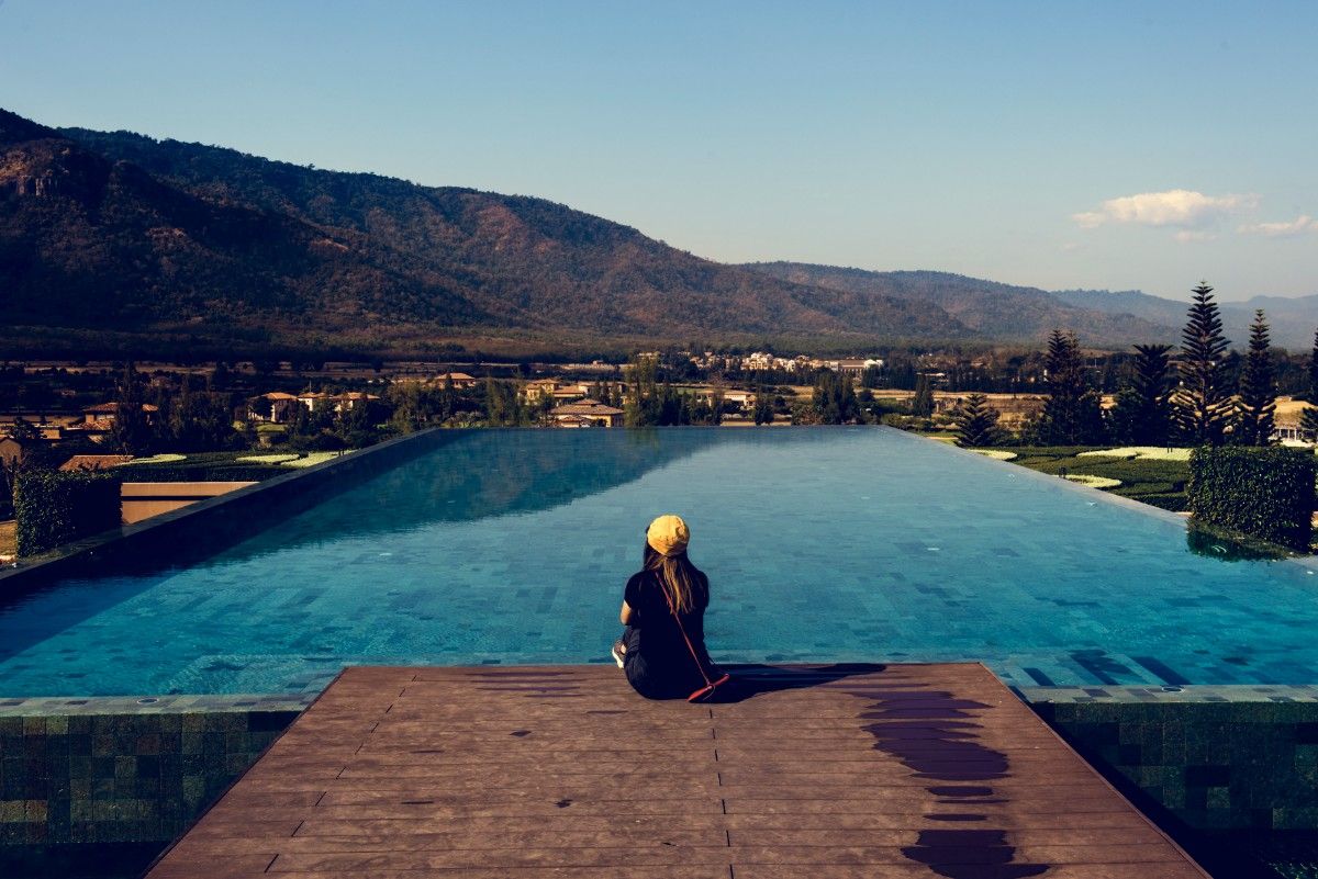  Christmas in Nigeria for Introverts: Lady enjoying a quiet time by the poolside with a mountain view. 
