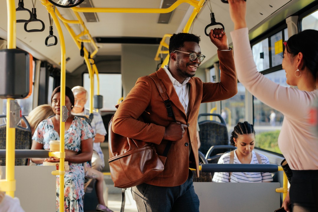 Nigerians are visiting Europe for the first time. A Nigerian man engages in a conversation on a bus.