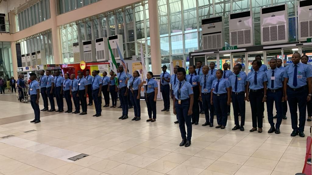 Security personnel standing at attention in a Nigerian airport.
