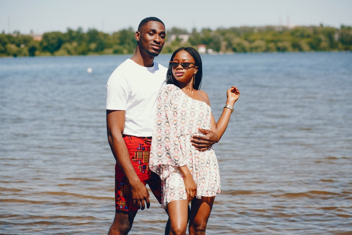 Beautiful Nigerian couple posing in front of a beach in one of the affordable honeymoon destinations for Nigerians.