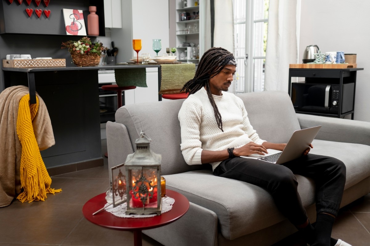 Nigerian man working on his laptop using electricity.
