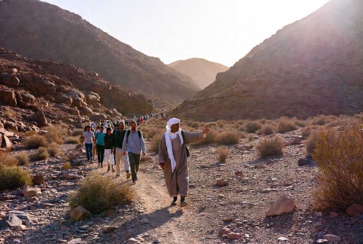 A local Berber guide leading a small tourist group through a Moroccan mountain trail