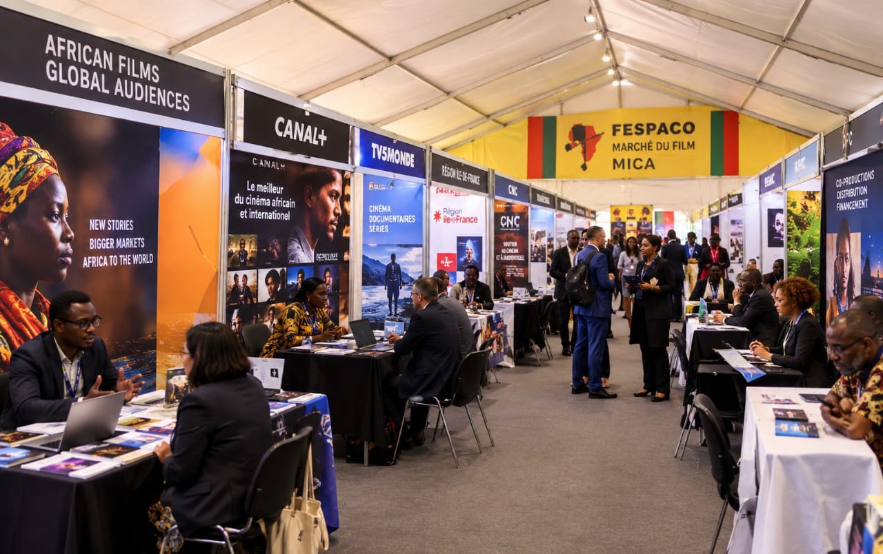 Exhibitor stands inside the MICA film market tent at the Fespaco film festival, where distributors and buyers meet.